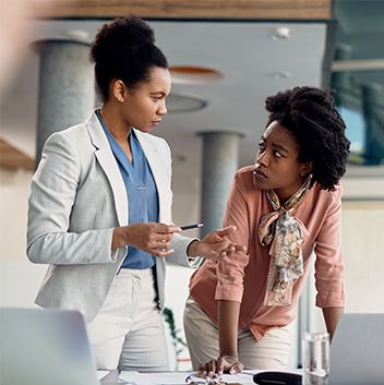 Two african american professional women discussing Standards